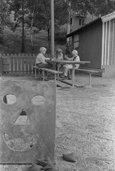 Svezia - Bambini seduti ad un tavolo di legno all'aperto