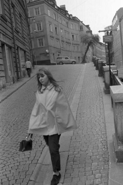 Svezia, Stoccolma - Södermalm - Giovane donna passaeggia per una strada lastricata nel centro cittadino