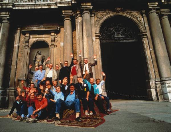 Dipendenti di azienda automobilistica - foto di gruppo - Si riconosce la facciata di un edificio religioso da sfondo all'immagine