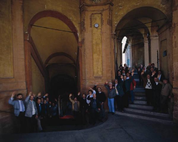 Dipendenti di azienda automobilistica - foto di gruppo - Si riconosce la facciata di un edificio religioso da sfondo all'immagine