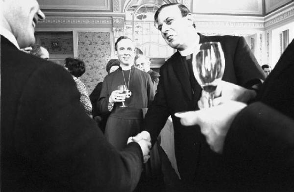 Ritratto di gruppo - uomini adulti in abiti ecclesiastici con bicchiere in mano a un ricevimento