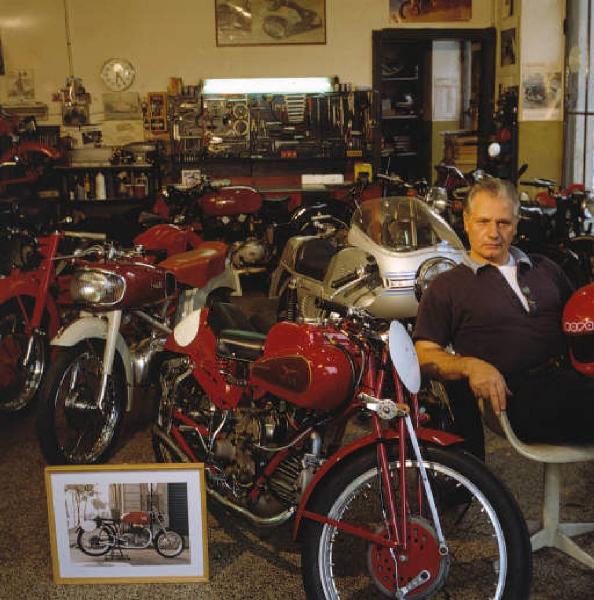 Officina di moto d'epoca - i titolari in posa accanto ad alcune motociclette