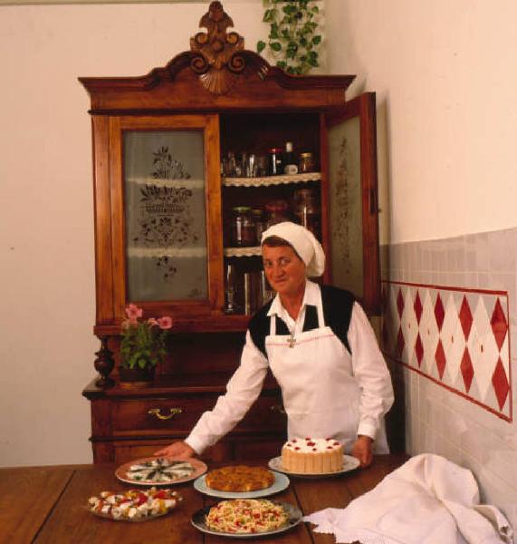Suor Germana in cucina mostra i cibi da lei preparati