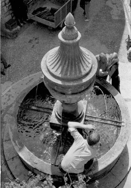 Fotografo su una fontana che riprende una coppia