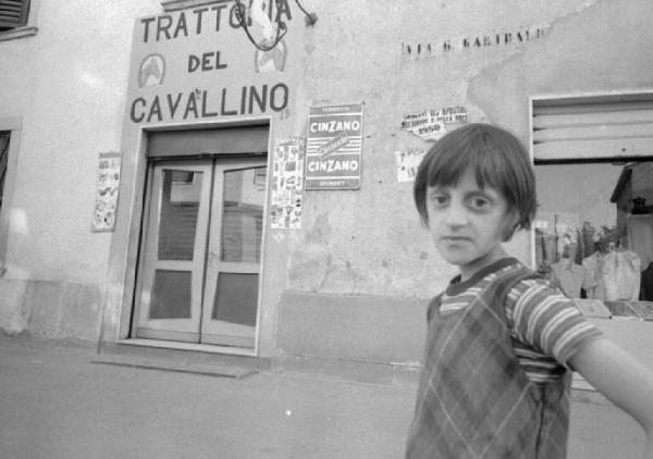 Bambina di fronte alla "Trattoria del Cavallino"