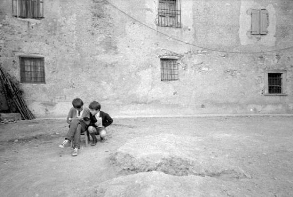 Due bambini nel cortile di un cascinale