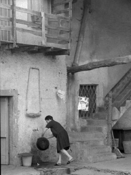 Donna con catino in cortile