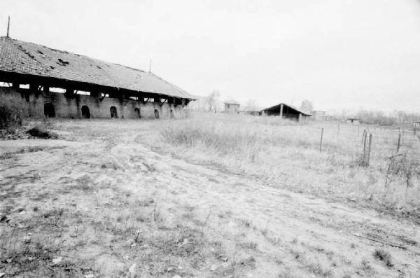 Campo con strada sterrata e cascinale