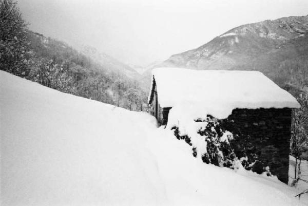 Casa montana di pietra ricoperta dalla neve