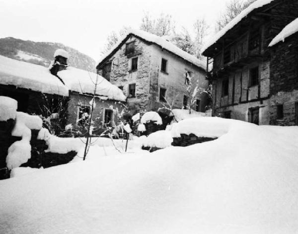 Paese montano con case di pietra coperto dalla neve