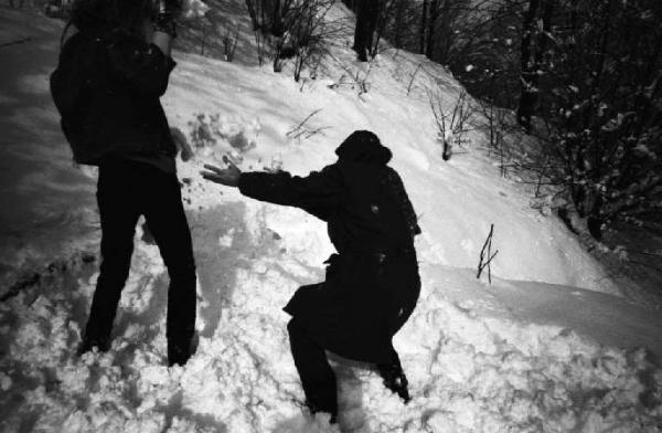 Coppia di amici in montagna che gioca con la neve