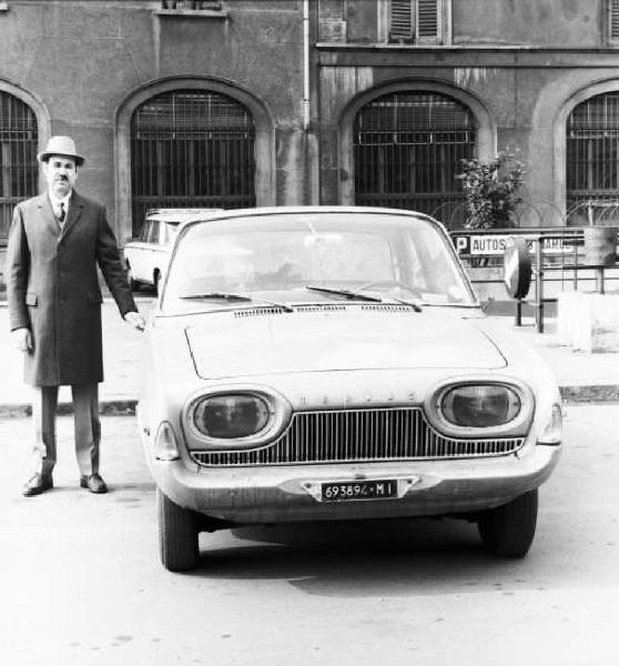 Milano - Ritratto di uomo con cappotto e cappello di fianco ad una automobile