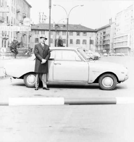 Milano - Ritratto di uomo con cappotto e cappello di fianco ad una automobile