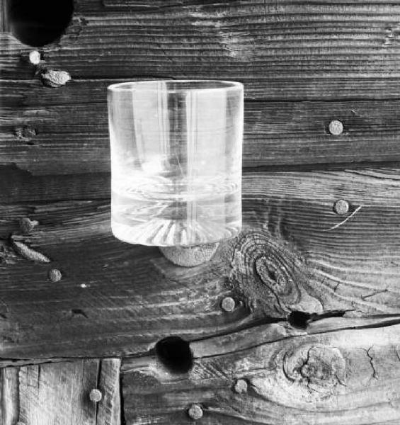 Stll - life con un bicchiere appogiato ad alcune assi di legno