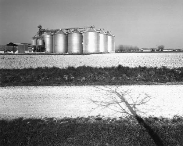 Silos per cereali - campo arato - strada sterrata