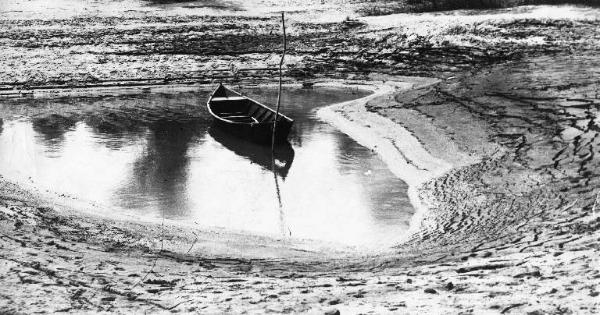 Barca in una pozza d'acqua - riva sabbiosa