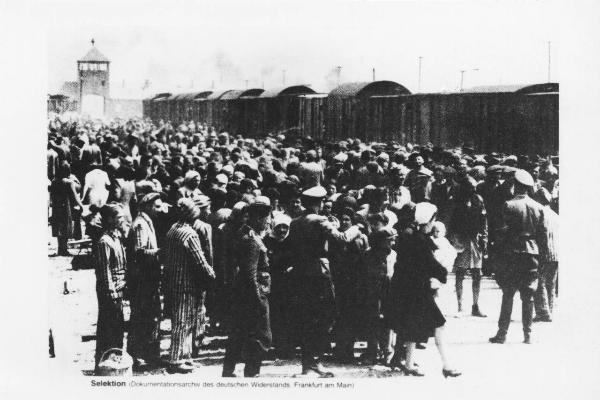 Seconda guerra mondiale - Nazismo - Polonia - Campo di concentramento di Auschwitz-Birkenau - Banchina della stazione - Arrivo e smistamento di ebrei dall'Ungheria - Deportazione - Treno con vagoni carro bestiame - Kanada Kommando - SS in divisa / In lontananza porta di ingresso del campo di concentramento con torretta