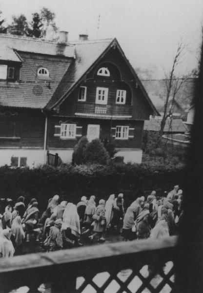 Seconda guerra mondiale - Nazismo - Germania - Marcia di evacuazione dei prigionieri (marcia della morte) dal campo di concentramento di Dachau a Bad Toelz - Fotografia dall'alto - Donne in cammino con coperte sulla testa - Strada cittadina - Casa