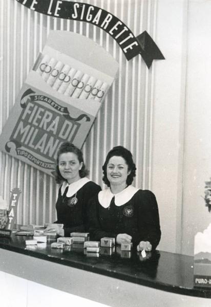 Fiera di Milano - Campionaria 1940 - Due donne ad un banco di sigarette in un interno