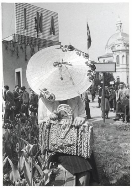 Fiera di Milano - Campionaria 1941 - Indossatrice con borsa e cappello di paglia all'esterno del padiglione dell'artigianato