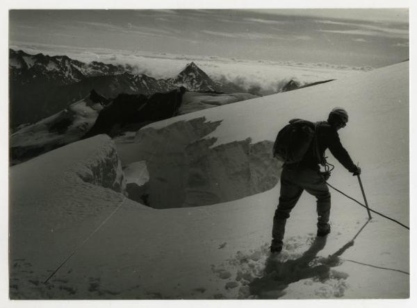 Alpinista davanti alla gola di un ghiacciaio in alta quota