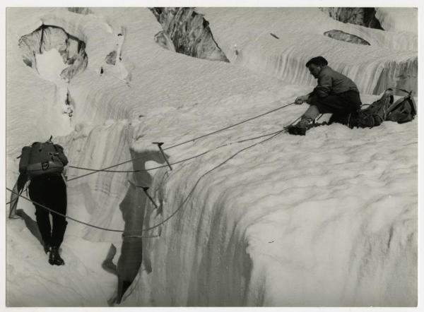 Due alpinisti presso una parete rocciosa innevata