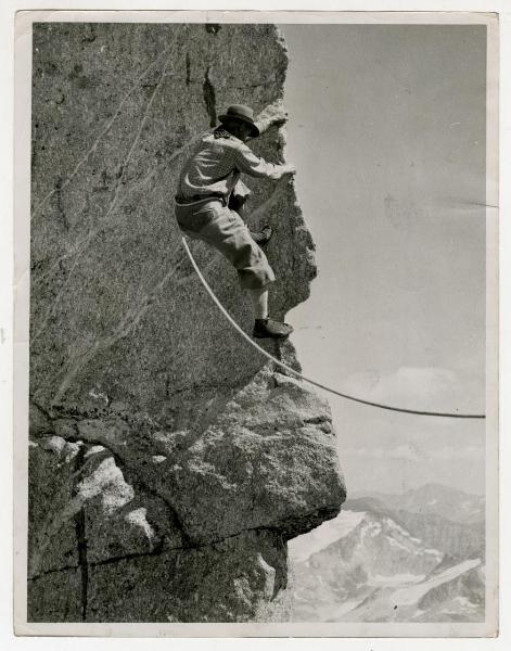 Alpinista che scala una roccia