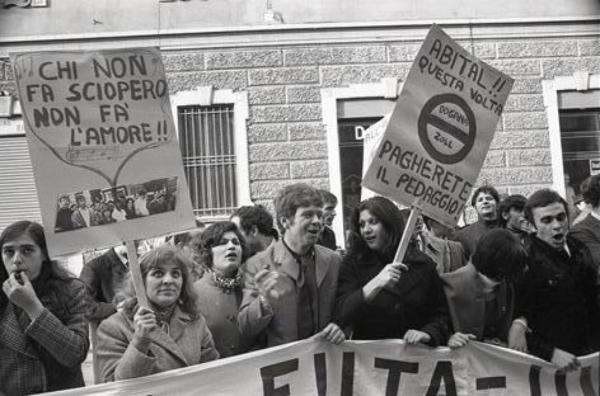 Sciopero dei lavoratori dell'Abital: primo piano di alcuni manifestanti con cartelli e fischietti