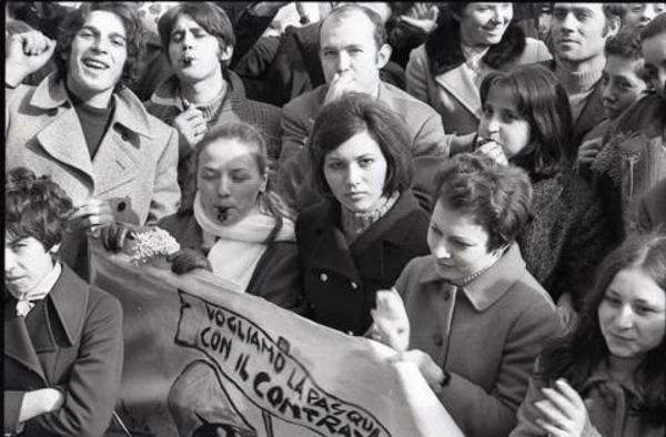 Corteo dei lavoratori Tessili a Legnano: primo piano di alcune lavoratrici. Una di loro ha in mano un mazzetto di mimosa