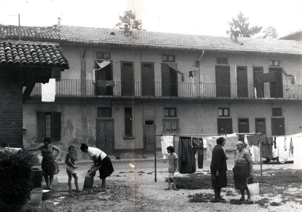 Milano - Quartiere Lampugnano - Cortile di cascina - Donne lavano i panni e chiacchierano - Bambini