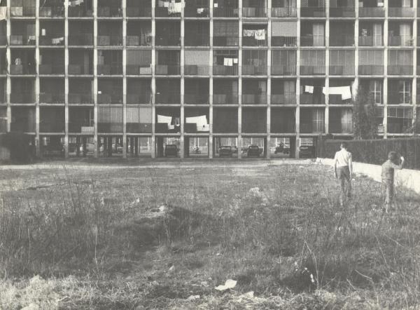 Milano - Piazza Axum - Le "case minime" - Due bambini camminano nel terreno incolto davanti all'edificio