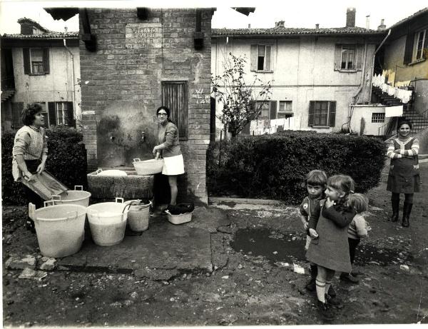 Milano - Quartiere Lampugnano - Cascina Cottica - Due donne fanno il bucato in cortile - Gruppo di bambini