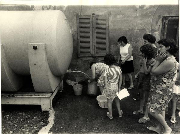 Milano - Quartiere San Siro - Via Novara - Cortile di cascina - Donne e bambini riempiono dei contenitori dalla cisterna - Disagio per mancanza di acqua