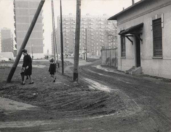 Milano - Quartiere Gratosoglio - Strade impraticabili - Mamma e bambino  camminano nel fango