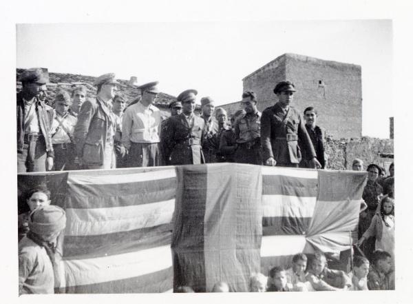 Spagna - Guerra civile spagnola - Francesco Scotti (secondo da sinistra sul palco) con altri compagni assiste a un discorso tenuto alle reclute della 60a divisione - Bandiere