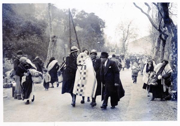 Perpignan (Francia) - Guerra civile spagnola - La "Retirada" - Due guardie trasportano una bambina ferita - Donne cariche di masserizie osservano la scena - Colonna di profughi - Bambini