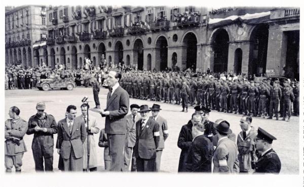 Torino - Piazza Vittorio Veneto - Festa della Liberazione - Il presidente del Comitato di Liberazione Nazionale del Piemonte Franco Antonicelli parla alla folla - Partigiani - Automobile - Bandiere