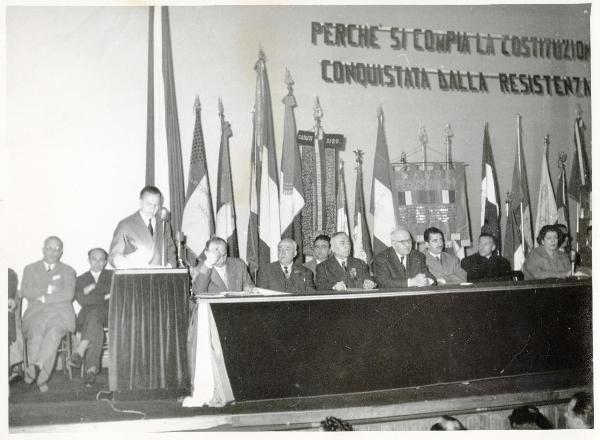 Milano - Teatro dal Verme - Quarto Congresso nazionale dell'ANPI - Tavolo degli oratori - Francesco Scotti al microfono - Bandiere - Stendardi - Scritte