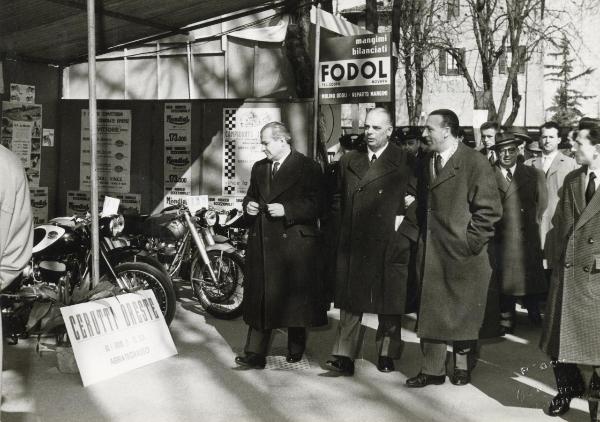 Abbiategrasso - Fiera Agricola Regionale 1958 - Francesco Scotti in visita con un gruppo di persone - Motociclette - Cartelli