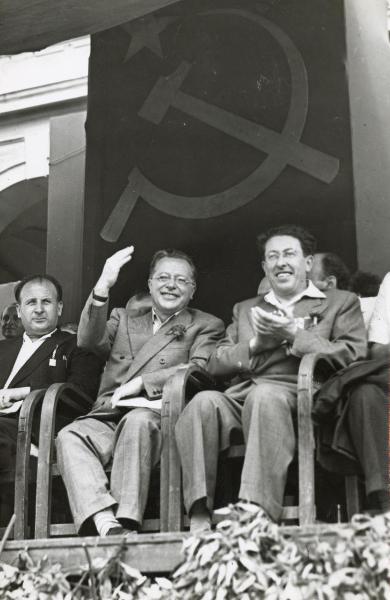 Firenze - Festa nazionale de l'Unità 1949 - Palmiro Togliatti seduto tra Vittorio Bardini (destra) e Pietro Secchia, saluta la folla dal palco - Ritratto di gruppo - Bandiera con i simboli della falce e martello