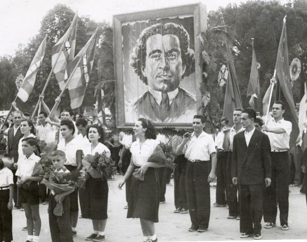 Firenze - Festa nazionale de l'Unità 1949 - Sfilata per le vie della città - Spezzone di corteo con manifestanti che portano in spalla il ritratto di Gramsci  - Uomini con bandiere - Donne e bambini con mazzi di fiori 
