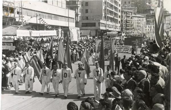 Genova - Festa nazionale de l'Unità 1950 - Sfilata per le vie della città - Spezzone di corteo con  gli operai della Fiat che indossano tute con la scritta Lingotto - Bandiere - Striscioni - Cartelli