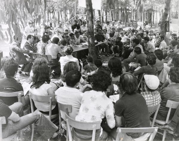 Bari - Festa nazionale d'apertura de l'Unità 1974 - Incontro delle delegazioni operaie del Nord e del Sud - Folla radunata all'aperto - Tavolo della discussione - Bruno Trentin al microfono