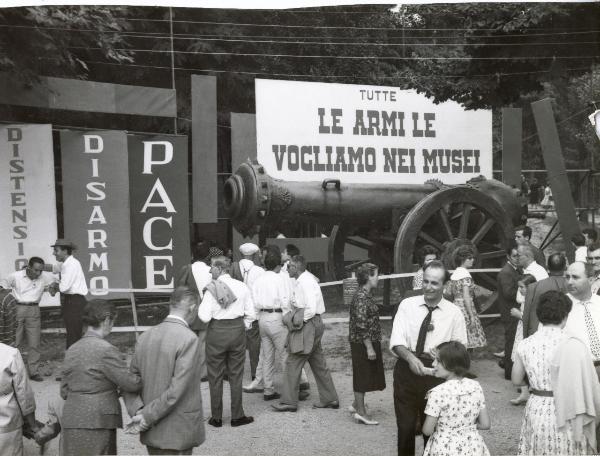 Ferrara - Festa nazionale de l'Unità 1960 - Folla a passeggio - Installazione con un grande cannone - Cartelli