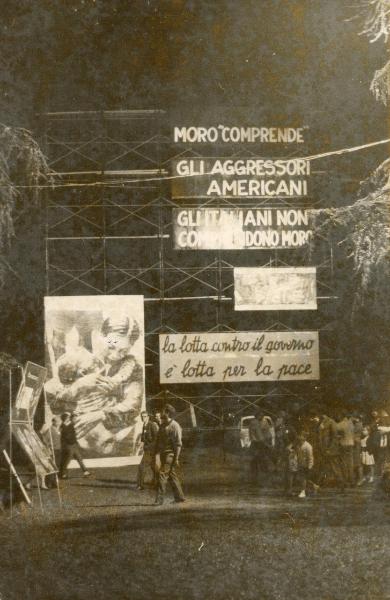 Firenze - Festa provinciale de l'Unità 1960 - Spazio allestito con cartelli di protesta su strutture metalliche - Folla a passeggio - Veduta notturna - Illuminazione