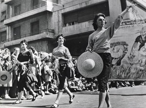 Genova - Festa nazionale de l'Unità 1955 - Sfilata per le vie della città - Spezzone di corteo con le mondine che portano mazzi di riso - Cartelli - Folla