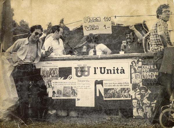 Kassel (Germania) - Festa de l'Unità 1978 - Centro culturale - Giovani italiani presso uno stand - Ritratto di gruppo - Cartelli - Manifesti