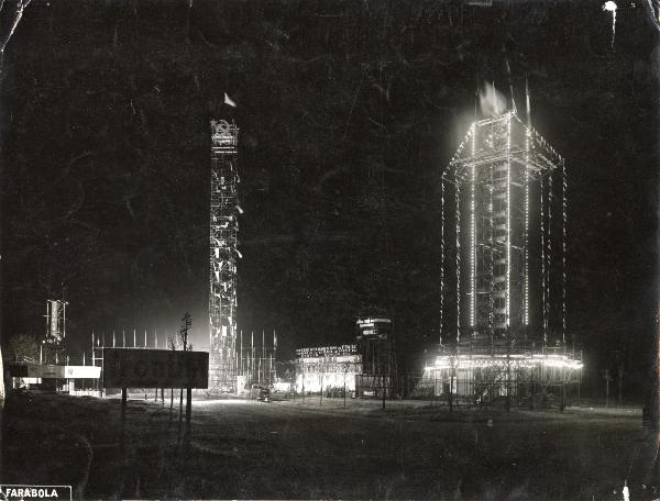 Milano - Festa nazionale de l'Unità 1953 - Parco Lambro - Veduta notturna delle due torri in metallo - Bandiere - Simboli - Cartelli - Illuminazione