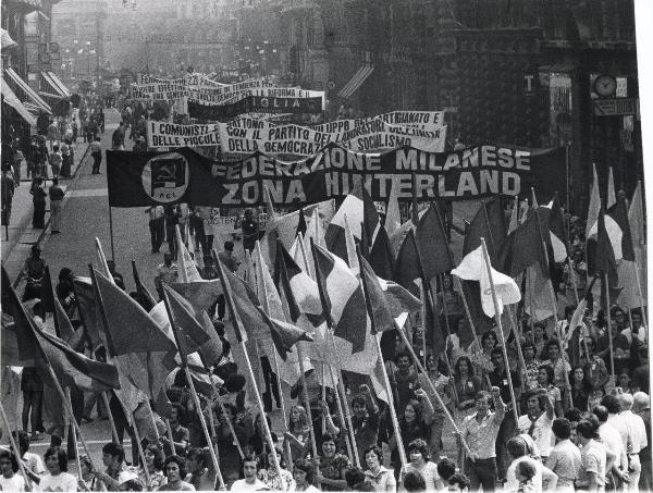 Milano - Festa nazionale de l'Unità 1973 - Manifestazione di chiusura - Spezzone di corteo con la delegazione della Federazione milanese del PCI - Giovani portano bandiere e salutano con il pugno chiuso alzato - Striscioni - Folla