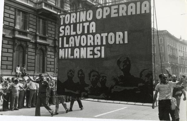 Milano - Festa nazionale de l'Unità 1973 - Manifestazione di chiusura - Spezzone di corteo con i lavoratori di Torino - Manifestanti salutano con il pugno chiuso alzato - Cartello